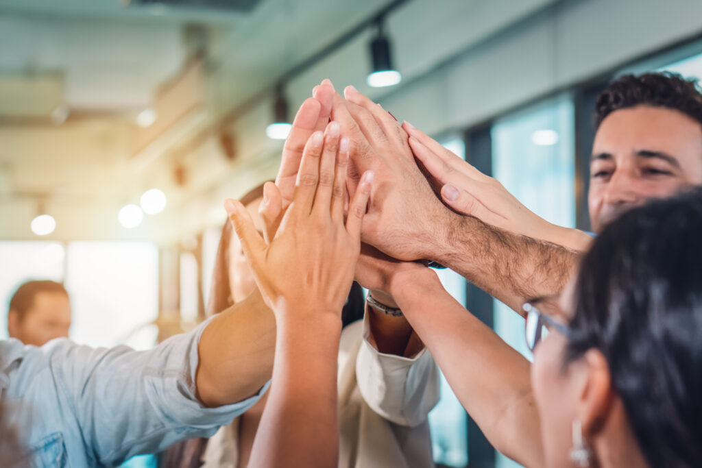 business people teamimg up and making highfive to cheer up team spirit to success